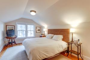 a bedroom with a large white bed and a television at Grand Lakefront Home in Warren with Expansive Patio! in Warren