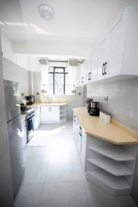 a kitchen with white cabinets and a white floor at Urban Living 2Br Westlands, King & Queen size Beds in Nairobi