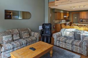 Una sala de estar con dos sofás y una mesa. en Tree Tops 35, en Big White