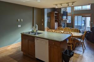 Una cocina con fregadero y una mesa con sillas. en Tree Tops 35, en Big White 14 fotos más