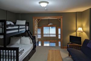 ein Schlafzimmer mit Etagenbetten und ein Wohnzimmer mit einem Sofa in der Unterkunft Tree Tops 35 in Big White