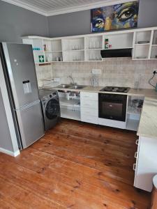 a kitchen with a refrigerator and a washer and dryer at 9 Lourens River in Cape Town