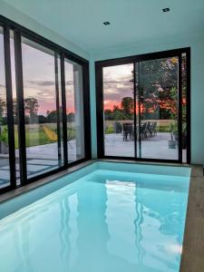 una piscina en una casa con ventanas en Chambre dans Villa proche Rennes - Cuisine, Entrée indépendante, en Laillé