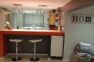 a kitchen with a bar with two stools and a mirror at Oceania Depto in Mar Azul