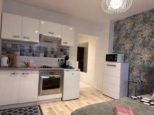 een keuken met witte kasten en een fornuis met oven bij Nice Stay Apartment Centrum in Warschau