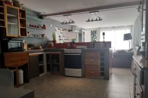 a kitchen with a stove and a couch in a room at Oceania Depto in Mar Azul