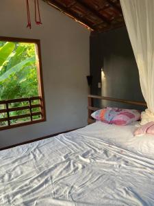 1 dormitorio con 1 cama grande y ventana en The Bright Houses en Moreré