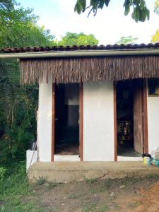 una pequeña casa con techo de paja en The Bright Houses en Moreré
