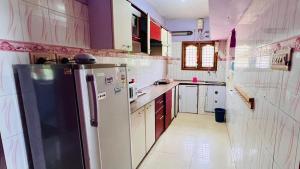 a kitchen with a refrigerator and a sink at HIlltop Cottage Homestay in Ooty