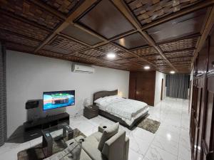 1 dormitorio con 1 cama y TV. en Amazing Grace Villa en Accra
