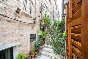 an alley with plants on the side of a building at Plaza Royal in the centre in Dubrovnik