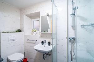 a white bathroom with a sink and a shower at Plaza Royal in the centre in Dubrovnik +38 photos