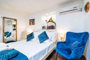 a bedroom with a bed and a blue chair at Plaza Royal in the centre in Dubrovnik