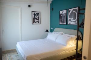 1 dormitorio con 1 cama con pared verde en Piccolo Torino Rooms, en Canicattì