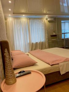 1 dormitorio con cama y mesa con mando a distancia en Квартира в центрі Світлі мрії Avenue Myru35 en Chernihiv