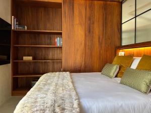 1 dormitorio con 1 cama con paredes y estanterías de madera en Hostal del vino LA COSTERA, en Altea