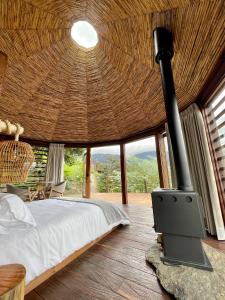 a bedroom with a bed and a woodburning stove at Tsia Bie Hotel in Choachí