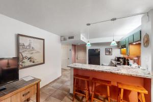 uma cozinha com um bar e uma sala de estar em Gulfview I #207 em South Padre Island