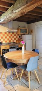 une cuisine avec une table en bois et un vase de fleurs. dans l'établissement Maison La Denolais Carnet Mont-Saint-Michel, à Saint-James