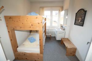 a room with two bunk beds and a bench at Villa Hartenfels 2 in Scuol