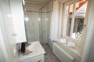 a white bathroom with a sink and a window at Villa Hartenfels 2 in Scuol +12 photos