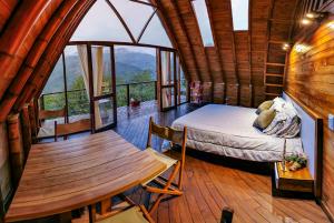 a bedroom in a log cabin with a bed and a table at Glamping Corazón del Molino in Ubaque +35 photos