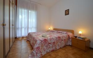 een slaapkamer met een bed en een tafel met een hoed erop bij Residenza Orsa Maggiore in Lignano Sabbiadoro