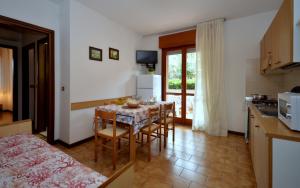 cocina y comedor con mesa y sillas en Residenza Orsa Maggiore, en Lignano Sabbiadoro