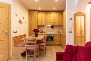 a kitchen with wooden cabinets and a table and chairs at Bilo al Piccolo Gufo in Andalo