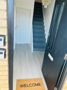 una alfombra de bienvenida en el suelo de un pasillo con una escalera en Elegant Downtown Escape en Londres