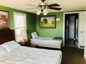 ein Schlafzimmer mit zwei Betten und einem Deckenventilator in der Unterkunft The Wellington Lake Cottage in Middlebury