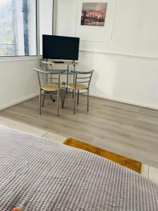 a table and chairs in a room with a television at Elegant Downtown Escape in London