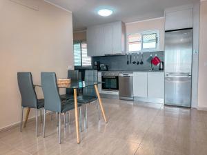 a kitchen with a table and chairs and a refrigerator at Attico 512 - Golf del Sur in San Miguel de Abona