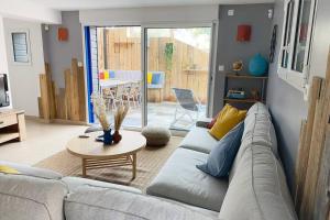 a living room with a couch and a table at L’appart classé 4* in Longeville-sur-Mer