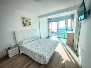 a bedroom with a bed and a large window at Attico 512 - Golf del Sur in San Miguel de Abona +34 photos