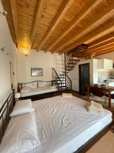 duże łóżko w pokoju z drewnianym sufitem w obiekcie Michel Studios w Kalawricie