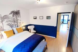a bedroom with a blue and white bed and a mirror at Rooftop Wohnung Kehl bei Strasbourg in Kehl am Rhein