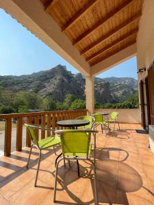 a patio with chairs and tables and mountains in the background at Michel Studios in Kalavrita