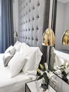 a bedroom with a white bed with a large headboard at MINT Boutique Studio Apartments in Zagreb