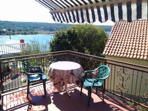 a table and chairs on a balcony with a view of the water at Apartman Amalija in Gornji Karin