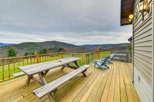 une terrasse en bois avec une table de pique-nique et des chaises. dans l'établissement Charming New York Chalet with Hot Tub and Game Room!, à Preston Hollow