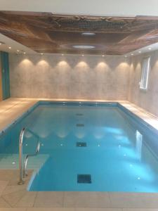 a large swimming pool with blue water in a room at Domitys Le 225 in Levallois-Perret