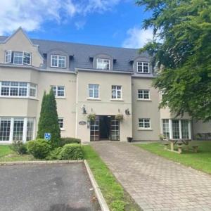 a large house with a driveway in front of it at Spacious 2 bedroom apartment in Killarney in Killarney