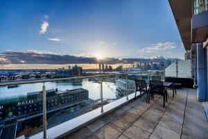 a balcony with a table and chairs on top of a building at Austin David Apartments ExCeL in London