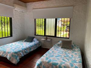 - une chambre avec 2 lits et 2 fenêtres dans l'établissement Villa Zunilda, à Rivera