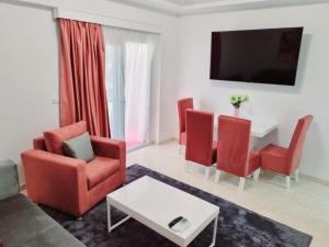 a living room with red chairs and a table at Selena Bay Hurghada - Pink Apartment in Hurghada