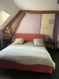 a bed with a red headboard in a room at Maison de 4 chambres avec jardin clos et wifi a Arcy Sainte Restitue in Arcy-Sainte-Restitue