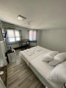 ein Schlafzimmer mit einem großen Bett mit weißer Bettwäsche und Kissen in der Unterkunft Heybeliada Pansiyon in Istanbul