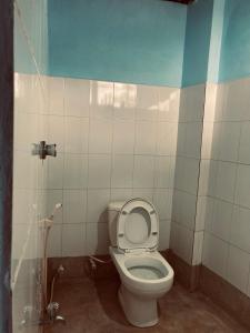 a bathroom with a toilet with the lid up at Railway Hostel in Matara