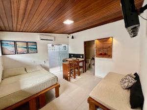 a room with a bed and a desk and a kitchen at Pousada Ilha do Campeche in Florianópolis